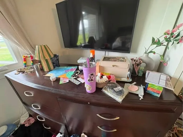 Dresser before cleaning, covered in papers and bottles